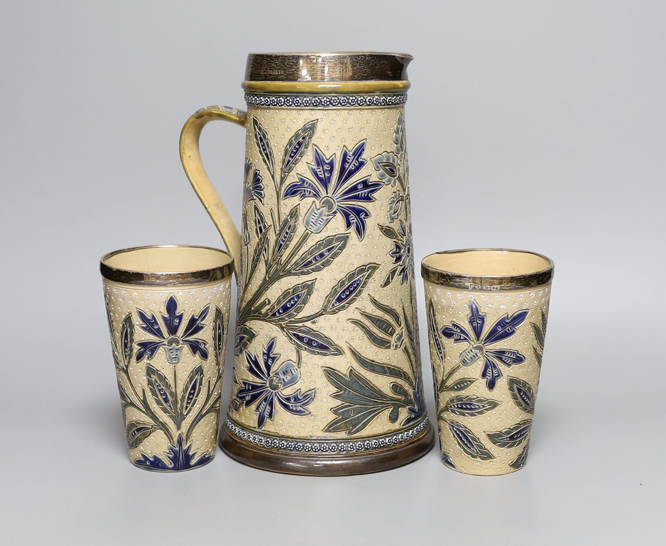 A silver mounted Doulton jug by Louisa J Davis, 26.5cm tall, and a pair of matching beakers